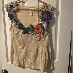 Asymmetrical sleeveless top with gorgeous appliqué neckline!